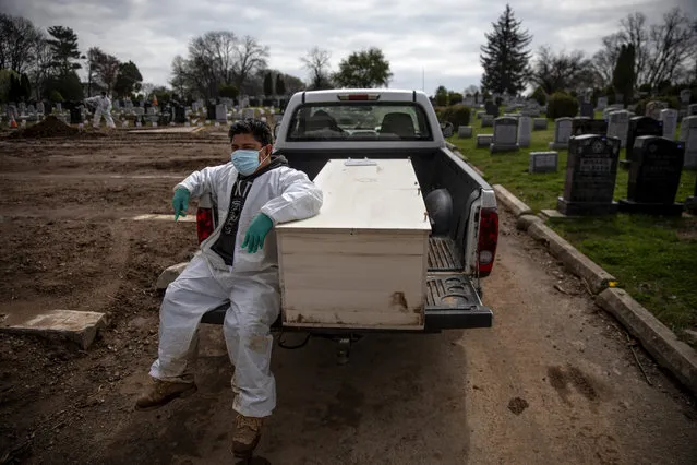 Gravedigger Thomas Cortez accompanies a casket as it's brought to the plot for burial at Hebrew Free Burial Association's Mount Richmond Cemetery in the Staten Island borough of New York, Wednesday April 8, 2020. The group serves Jews who mostly die with little or nothing. A century ago, it buried garment workers killed in the Triangle Shirtwaist fire and those who fell to the Spanish flu. More recently, it was Holocaust survivors who fled Europe. And now, those dying of the coronavirus. (Photo by David Goldman/AP Photo)