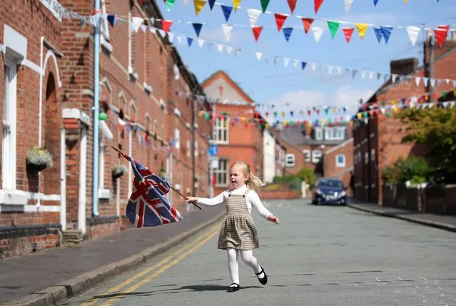 A young girl with a flag on Cambrian Road on the 75th Anniversary of VE Day, Chester, Britain, May 8, 2020. (Photo by Molly Darlington/Reuters)