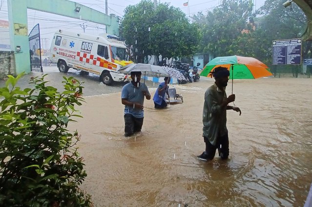 People walk outside the Tambaram Government Hospital flooded following heavy rains along the Bay of Bengal coast in  Chennai, India, Monday, December 4, 2023. Authorities issued warnings for tropical storm Michuang, which is likely to hit the southern coast on Tuesday with maximum sustained winds of 90-100 kilometers (56-62 miles) per hour with gusts up to 110 kph (68 mph), the Indian Meteorological Department said. (Photo by AP Photo)