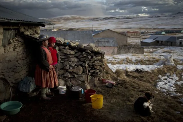 In this July 9, 2016 photo, Rosa Carcabusto and her daughter Maria Luque stand outside their home before cooking a dinner soup of wheat and dried potatoes, in San Antonio de Putina in the Puno region of Peru. Poverty has driven many farmers' children from their homes to work in illegal mines or Peru's flourishing cocaine trade. (Photo by Rodrigo Abd/AP Photo)
