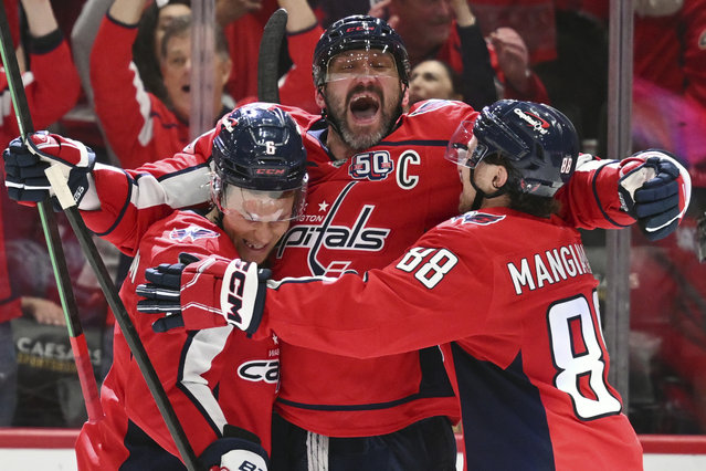 Washington Capitals left wing Alex Ovechkin (8) celebrates with Capitals defenseman Jakob Chychrun, left, and left wing Andrew Mangiapane after tying Wayne Gretzky’s 894 career goal record on this shot during the third period of an NHL hockey game against the Chicago Blackhawks at Capital One Arena in Washington, DC on April 4, 2025. (Photo by John McDonnell/For The Washington Post)