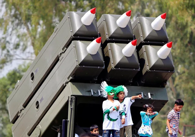 Children stand on a multiple rocket launcher system during a ceremony to commemorate Defence Day, or Pakistan's Memorial Day, at the Nur Khan airbase in Islamabad, Pakistan, September 6, 2016. (Photo by Faisal Mahmood/Reuters)