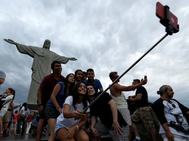 Tourists pose for a selfie before a ceremony with the Paralympic torch at the Christ the Redeemer statue ahead of the 2016 Rio Paralympic games in Rio de Janeiro, Brazil September 6, 2016. (Photo by Carlos Garcia Rawlins/Reuters)
