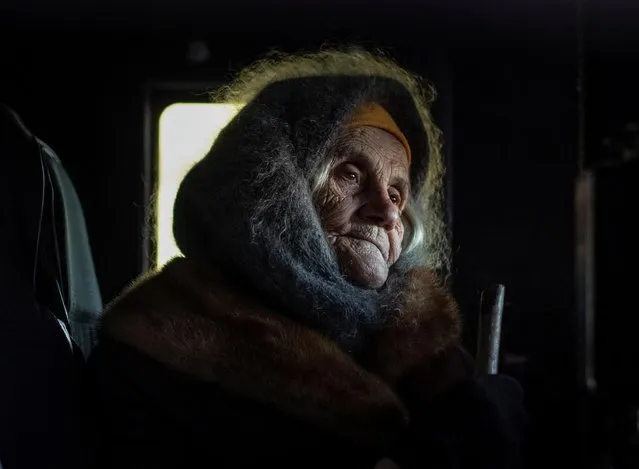 A local resident Oleksandra Koshkina, 85, sits in a car as she comebacks in her village of Torske near a frontline, amid Russia's attack on Ukraine, Donetsk region, Ukraine on December 20, 2022.. (Photo by Oleksandr Ratushniak/Reuters)