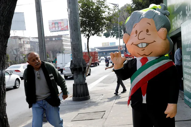 A man looks at an inflatable costume representing Andres Manuel Lopez Obrador, presidential pre-candidate of the National Regeneration Movement (MORENA) for the presidential election 2018 outside a shop in Mexico City, Mexico January 19, 2018. (Photo by Carlos Jasso/Reuters)