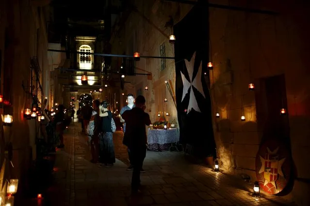 Visitors take photos of each other during the activity "Birgu by Candlelight" in the medieval city of Birgu, also known as Vittoriosa, outside Valletta, Malta, October 10, 2015. (Photo by Darrin Zammit Lupi/Reuters)
