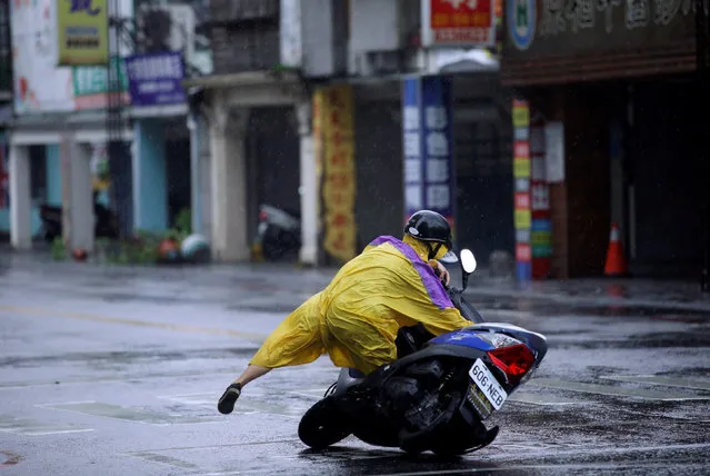 A motorcyclist falls along a road as Typhoon Megi hits Hualien, eastern Taiwan, September 27, 2016. (Photo by Tyrone Siu/Reuters)