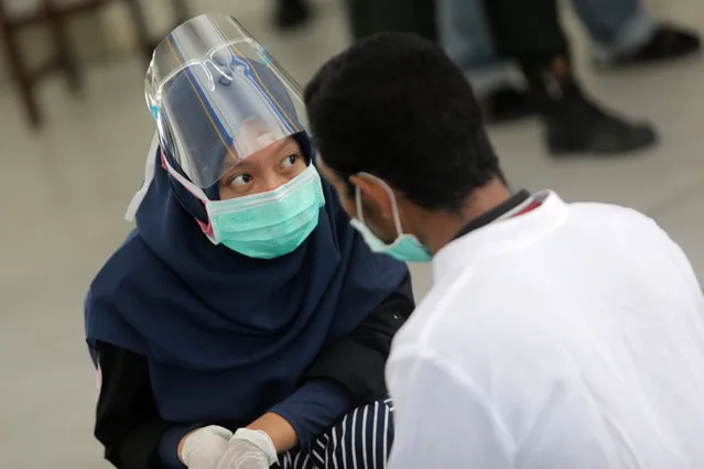 A doctor carries out a health check up for a Shariah defendant during his caning punishment for raping a child in Banda Aceh, Aceh, Indonesia, 24 September 2020. A child rapist faced 196 lashes after being found guilty by the court in Aceh this year. Aceh is the only province in Indonesia that has implemented Sharia law and considers lesbian, gay, bisexual relationships and s*x outside of marriage as Sharia law violations. (Photo by Hotli Simanjuntak/EPA/EFE)