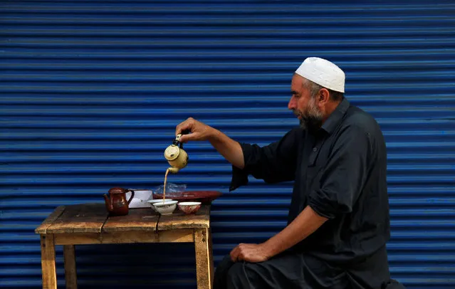 A man serves himself some tea as he waits for the start of Eid al-Adha prayers in Peshawar, Pakistan September 13, 2016. (Photo by Fayaz Aziz/Reuters)