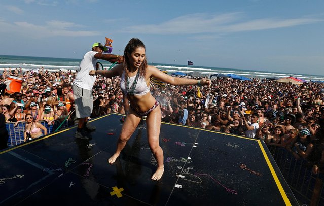 People participate in a wet t-shirt contest on a stage while people party and celebrate on the beach at Clayton's Beach Bar and Grill in South Padre Island, Texas, USA, 11 March 2018. (Photo by Larry W. Smith/EPA/EFE)