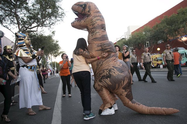 A person dressed in a dinosaur suit poses at the West Hollywood Halloween Costume Carnaval, which attracts nearly 500,000 people annually in West Hollywood, California October 31, 2015. (Photo by Jonathan Alcorn/Reuters)