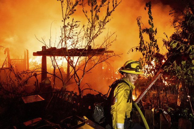 A firefighter battles the 6-5 Fire burning through the Chinese Camp community of Tuolumne County, Calif., on Tuesday, September 2, 2025. (Photo by Noah Berger/AP Photo)