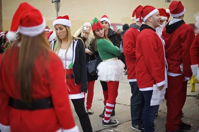 Ainsley Ashton (C), 24, joins others dressed in Santa Claus outfits waiting in line to attend an after-party for the “Running of the Santas” at the Electric Factory in Philadelphia, Pennsylvania December 13, 2014. (Photo by Mark Makela/Reuters)