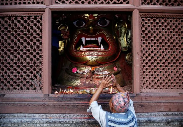 A devotee offers prayers to the idol of Bhairab during “Dashain”, a Hindu religious festival in Kathmandu, Nepal October 10, 2016. (Photo by Navesh Chitrakar/Reuters)