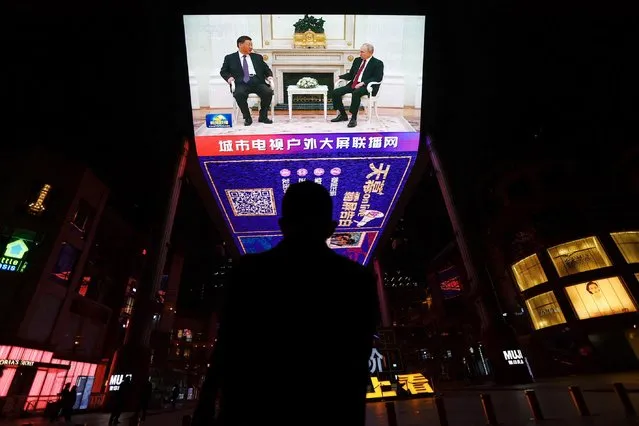 A man watches a screen broadcasting news footage of Russian President Vladimir Putin meeting Chinese President Xi Jinping at the Kremlin in Moscow, at a shopping area in Beijing, China on March 21, 2023. (Photo by Tingshu Wang/Reuters)