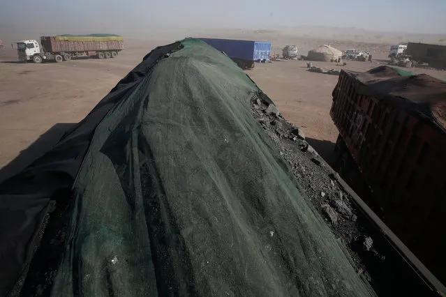 Trucks full of coal wait along the road at Tsagaan Khad, some 20 kilometres from the border with China in Khanbogd Soum in the Gobi desert, Mongolia, October 30, 2017. (Photo by Bazarsukh Rentsendorj/Reuters)