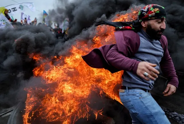 A Kurdish man jumps over bonfire as supporters of Pro-Kurdish Peoples' Democratic Party (HDP) mark the Nowruz (Newroz), or Kurdish New Year, in Istanbul, Turkey, 19 March 2023. Newroz or Nowruz, which means “new day” in the Persian language, marks the arrival of spring and the first day in the Iranian calendar. It is widely celebrated in the Persian and neighboring regions and recognized on the UNESCO List of the Intangible Cultural Heritage of Humanity. (Photo by Erdem Sahin/EPA/EFE/Rex Features/Shutterstock)