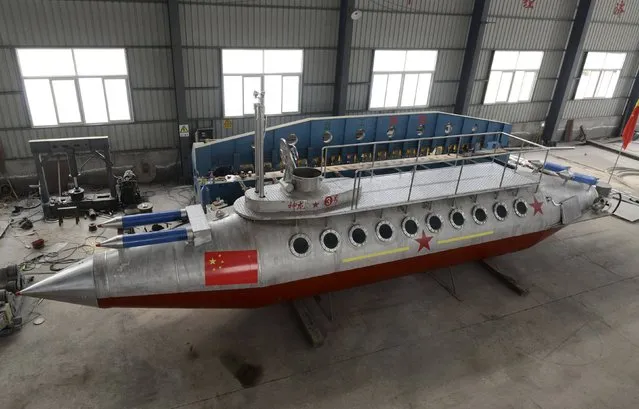 A homemade submarine named “Shenlong-3” made by Zhang Junlin, a 62-year-old retired prison guard, is pictured at a factory in Fuyang, Anhui province December 20, 2014. Zhang spent 2 years with his team to build the 15-metre-long (49-ft) submarine, which weighs about 25 tons and can hold up to 20 people. The submarine, the third one made by Zhang and his team, will be put under a test run in water soon, according to local media. (Photo by Reuters/China Daily)