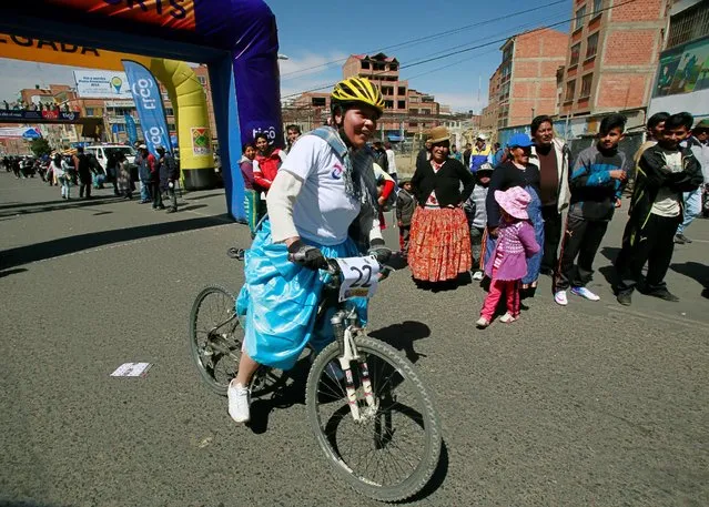 A participant crosses the finish line of the Cholita bike race in El Alto, on the outskirts of La Paz, Bolivia, October 29, 2016. (Photo by David Mercado/Reuters)