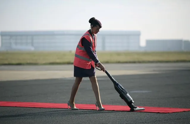 A worker vaccums the red carpet before the arrival of Colombia's President Juan Manuel Santos and his wife Maria Clemencia de Santos at Stansted airport in Stansted, Britain October 31, 2016. (Photo by Neil Hall/Reuters)