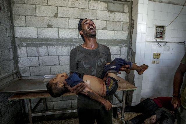 A Palestinian man cries while holding a relative killed in the Israeli bombardment of the Gaza Strip at a hospital morgue in Deir al-Balah, August 28, 2024. (Photo by Abdel Kareem Hana/AP Photo)