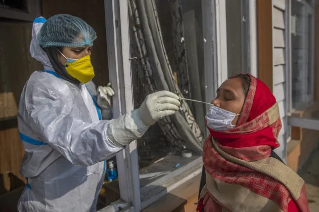 A health worker takes a nasal swab sample of a Kashmiri to test for COVID-19 in Srinagar, Indian-controlled Kashmir, Wednesday, January 20, 2021. The global death toll from COVID-19 topped 2 million last week as vaccines developed at breakneck speed are being rolled out around the world in an all-out campaign to vanquish the threat. (Photo by Dar Yasin/AP Photo)