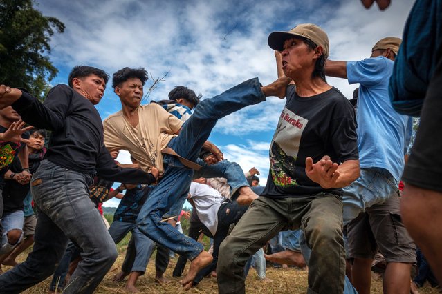 A number of men get kicking each other while participating in the “Sisemba” (kicking each other) tradition at Panggala, Indonesia on August 27, 2024. The tradition is an expression of gratitude for the crops and is based on the belief that the event will keep them enthusiastic for the work ahead to get the next plentiful crops. Without performing Sisemba, the people of Tana Toraja believe that there will be harvest failure. The tradition is claimed to uphold kinship values. Participants who have fallen are forbidden to be attacked, and those who are injured in Sisemba cannot hold grudge toward their opponents. (Photro by Hariandi Hafid/ZUMA Press Wire)