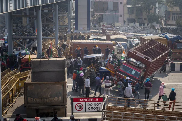 Protesting farmers drive a tractor into a truck, which was used as a barricade by police, as they make their way while marching to the capital breaking police barricades during India's Republic Day celebrations in New Delhi, India, Tuesday, January 26, 2021. Tens of thousands of farmers drove a convoy of tractors into the Indian capital as the nation celebrated Republic Day on Tuesday in the backdrop of agricultural protests that have grown into a rebellion and rattled the government. (Photo by Altaf Qadri/AP Photo)