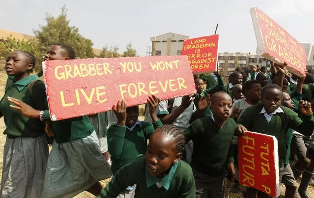 Students from Langata primary school hold placards as they protest against a perimeter wall illegally erected by a private developer around their school playground in Kenya's capital Nairobi, January 19, 2015. (Photo by Thomas Mukoya/Reuters)