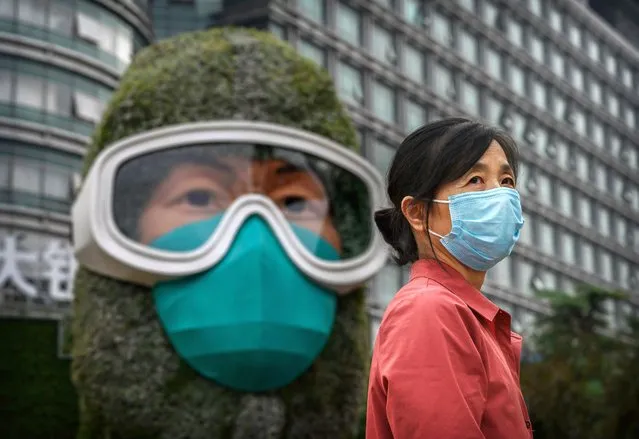 A Chinese woman poses for a photo in front of a flower display dedicated to frontline health care workers during the COVID-19 pandemic that was created with other floral decorations in advance of the country's national holidays, also known as Golden week on September 28, 2020 in Beijing, China. China will celebrate national day marking the founding of the People's Republic of China on October 1st.(Photo by Kevin Frayer/Getty Images)