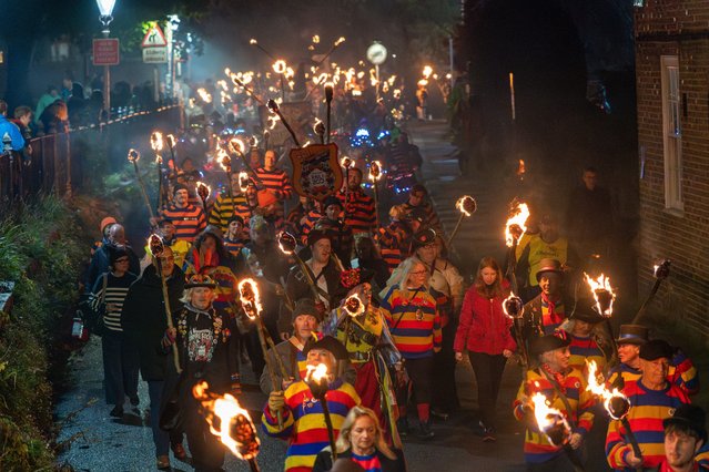 Members of local bonfire societies process with flaming torches through the streets of Hastings, East Sussex, UK in an annual ritual on October 13, 2024. (Photo by Ray Tang/London News Pictures)