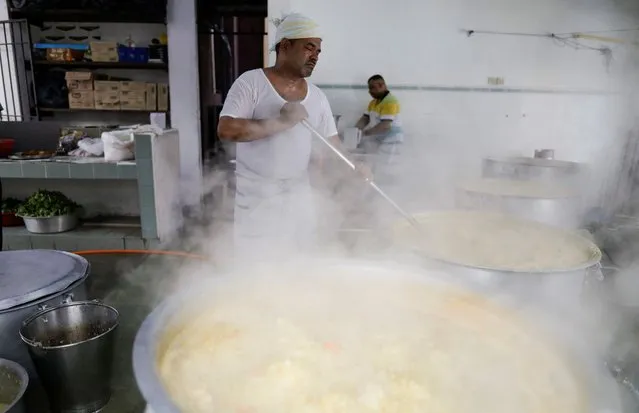 Cook, Hamid Sadakathullah, 46, stirs the porridge as he prepares the food for the community for them to break their fast on the first day of Ramadan at a mosque in Kuala Lumpur, Malaysia on March 23, 2023. (Photo by Hasnoor Hussain/Reuters)