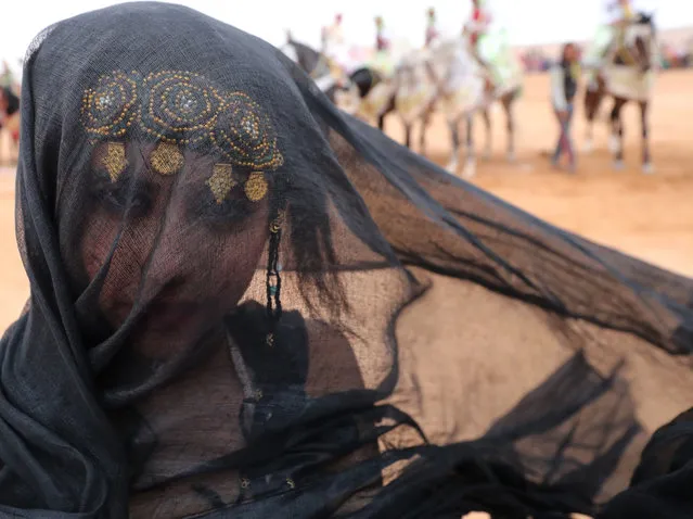 A Moroccan woman from the southern desert, wearing a traditional outfit, participates in the 14 th Tan- Tan Moussem Berber festival on July 08, 2018 in the western desert town of Tan- Tan. The festival, which is recognised by UNESCO as a “Masterpiece of the Oral and Intangible Heritage of Humanity”, is organised every year to promote local traditions and brings together nomadic tribes from northern Africa. (Photo by Karim Sahib/AFP Photo)