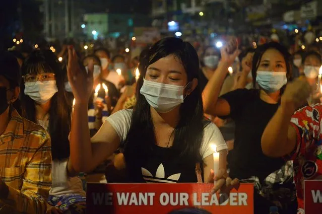 Protesters attend a candlelight night rally in Yangon, Myanmar, Saturday, March 13, 2021. Security forces in Myanmar on Saturday again met protests against last month's military takeover with lethal force, killing at least four people by shooting live ammunition at demonstrators. (Photo by AP Photo/Stringer)