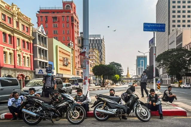 Security forces sit along a road divider in the downtown area of Yangon on March 10, 2021, as they continue to crackdown on demonstrations by protesters against the military coup. (Photo by AFP Photo/Stringer)