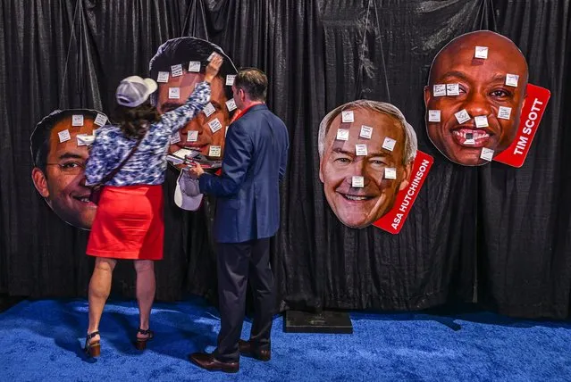 People put messages on the portraits of US 2024 presidential hopefuls at the Turning Point Action USA conference in West Palm Beach, Florida, on July 15, 2023. (Photo by Giorgio Viera/AFP Photo)