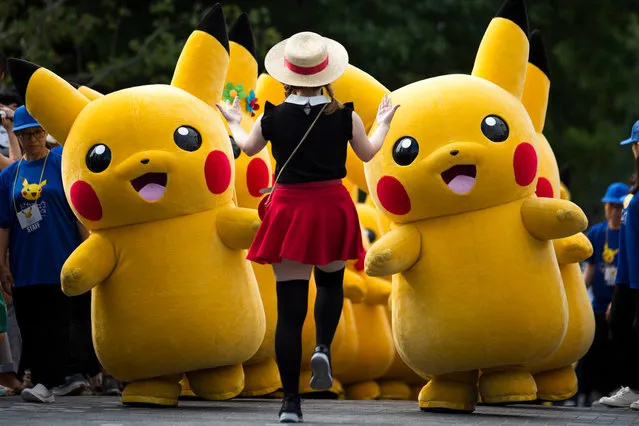 Performers dressed as Pikachu, a character from Pokemon series game titles, march during the Pikachu Outbreak event hosted by The Pokemon Co. on August 10, 2018 in Yokohama, Kanagawa, Japan. (Photo by Tomohiro Ohsumi/Getty Images)