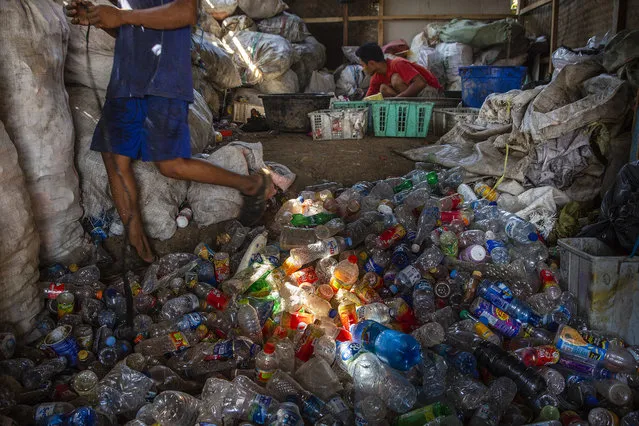 A man separates different kinds of plastic, which he will later sell, recycled from the Citarum river on August 28, 2018 outside Bandung, Java, Indonesia. (Photo by Ed Wray/Getty Images)
