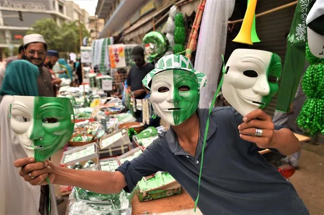 A vendor sells Guy Fawkes masks and items with the colors of the national flag at a market ahead of Independence Day celebrations in Karachi, Pakistan, 13 August 2023. Pakistan celebrates its 76th independence anniversary from British rule in 1947 on 14 August 2023. (Photo by Shahzaib Akber/EPA/EFE)