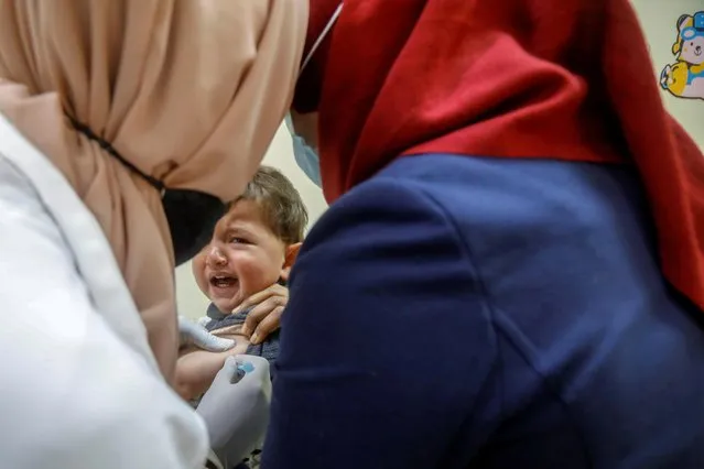 A Palestinian healthcare worker vaccinates a child during a lockdown imposed to prevent the spread of the coronavirus disease (COVID-19), in a clinic in Tubas in the Israeli-occupied West Bank on March 15, 2021. (Photo by Raneen Sawafta/Reuters)