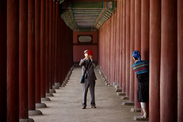 A man wearing a protective mask photographs his wife amid the coronavirus disease (COVID-19) pandemic at the Gyeongbok palace in Seoul, South Korea, May 3, 2021. (Photo by Kim Hong-Ji/Reuters)