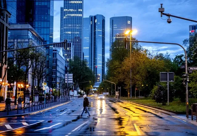 A man crosses a street shortly after the end of the curfew in central Frankfurt, Germany, Tuesday, May 11, 2021. (Photo by Michael Probst/AP Photo)