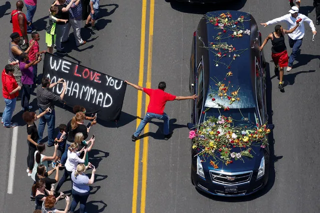 A banner stating “We Love You Muhammad” is displayed as well-wishers touch the hearse carrying the body of the late boxing champion Muhammad Ali during his funeral procession through Louisville, Kentucky, June 10, 2016. (Photo by Adrees Latif/Reuters)