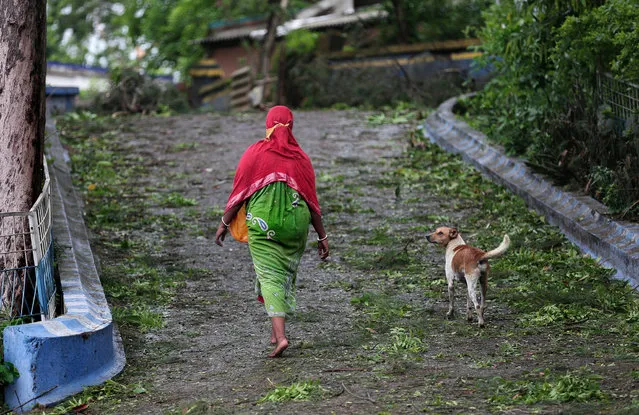A woman walks among fallen branches as Cyclone Yaas makes landfall in Digha, near the Bay of Bengal, south of Kolkata, India, 26 May 2021. (Photo by Piyal Adhikary/EPA/EFE)