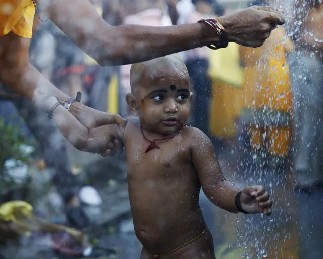 A child of a Hindu devotee is washed before beginning his pilgrimage to Batu Caves during Thaipusam in Kuala Lumpur, Malaysia, January 24, 2016. (Photo by Olivia Harris/Reuters)