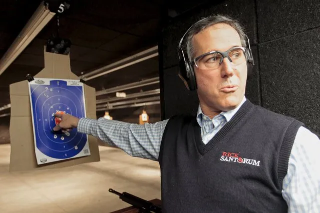 U.S. Republican presidential candidate Rick Santorum points to his target after taking target practice at the Central Iowa Impact shooting range in Boone, Iowa, January 30, 2016. (Photo by Brian C. Frank/Reuters)