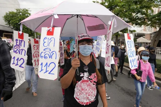 A pro-democracy supporter wears a face mask with the umbrella with sign saying “No to Article 112”, a legal provision in Thailand's Criminal Code concerning any defamation of the monarchy, as she participates in a rally in Bangkok, Thailand, Thursday, June 24, 2021. Anti-government protests expected to resume in Bangkok after a long break due partly to a surge in COVID-19 cases. Gatherings are planned for several locations across the capital, despite health officials mulling a week-long lockdown in Bangkok  to control a rampant virus surge. (Photo by Sakchai Lalit/AP Photo)