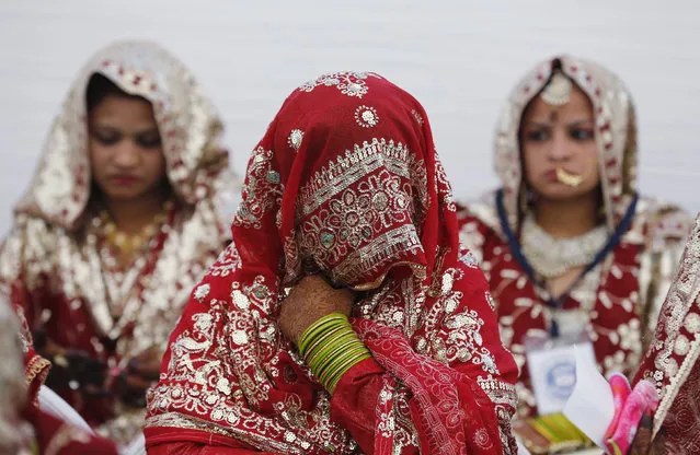 Muslim brides wait for the start of a mass marriage ceremony in Ahmedabad, India, February 7, 2016. A total of 84 Muslim couples from various parts of Ahmedabad on Sunday took wedding vows during the mass marriage ceremony organised by a Muslim voluntary organisation, organisers said. (Photo by Amit Dave/Reuters)
