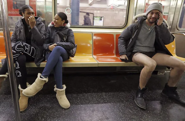 Passengers react to a man seated beside them without pants during the 18th annual No Pants Subway Ride, January 13, 2019, in New York. (Photo by Kathy Willens/AP Photo)