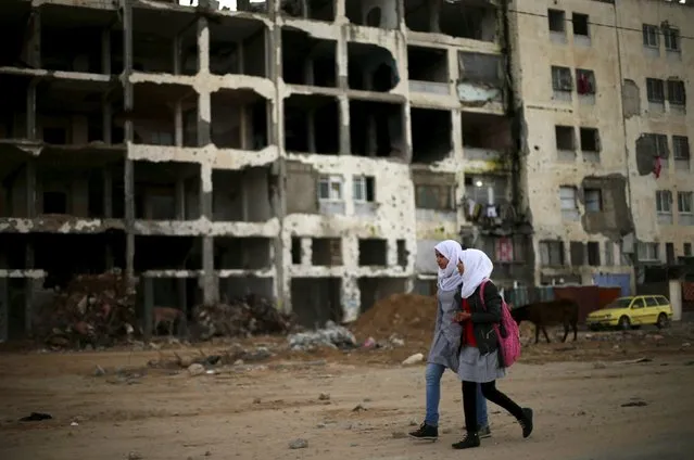 Palestinian schoolgirls walk past the remains of a residential building, destroyed during 2014 war, as they return to their homes on a winter day in the northern Gaza Strip, February 10, 2016. (Photo by Mohammed Salem/Reuters)